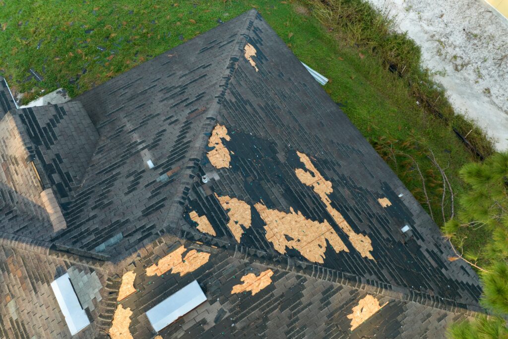 severely damaged roof with missing shingles after an intense storm